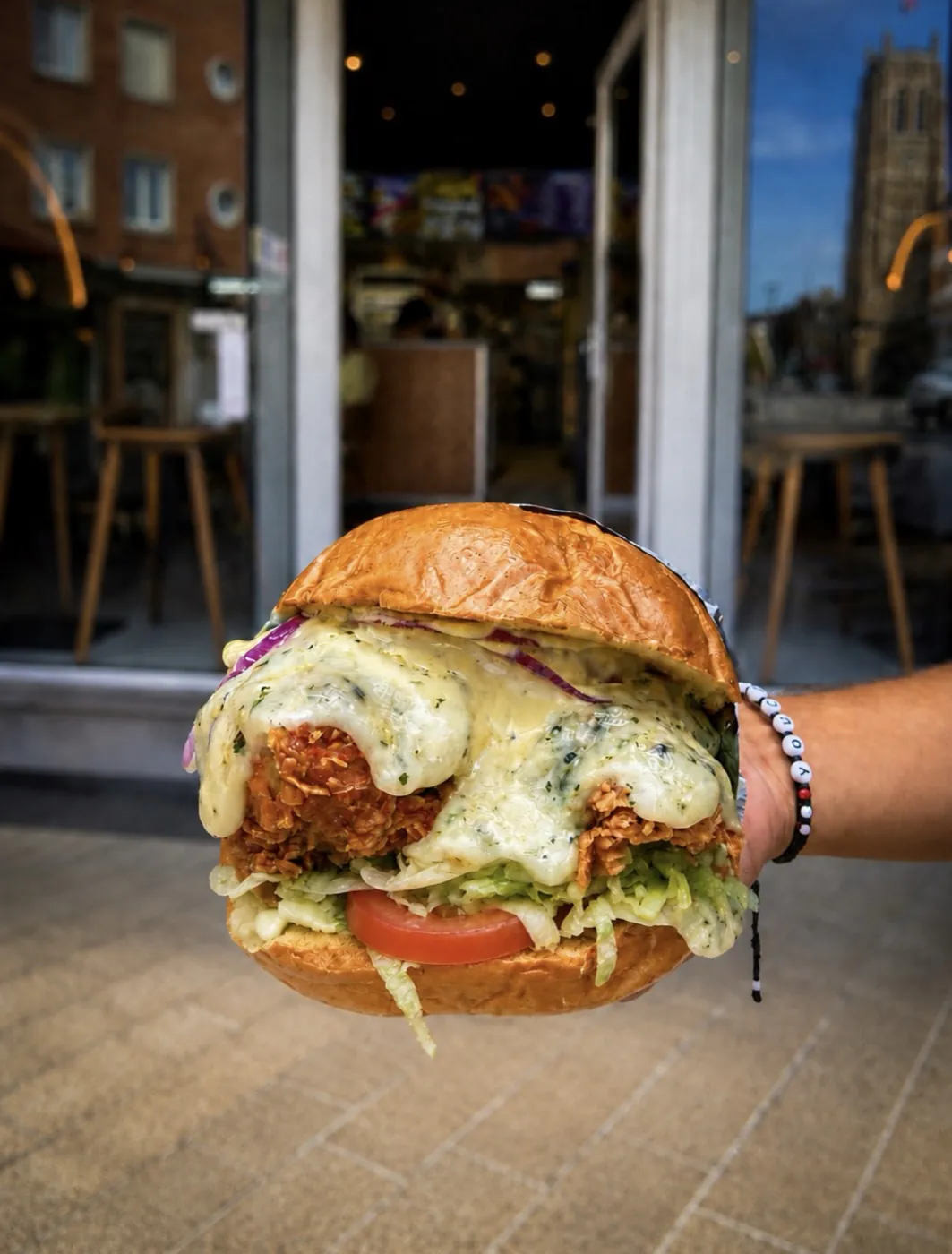 Burger au poulet frit tenu en main
